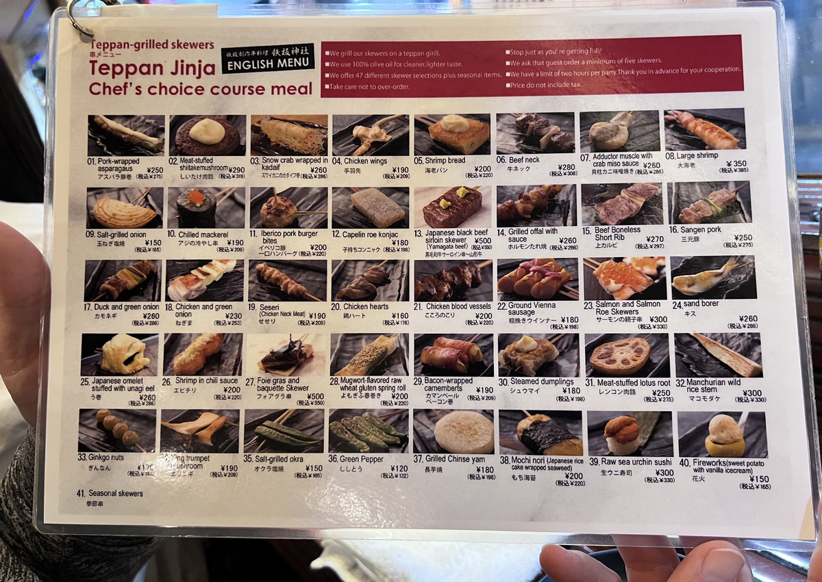 Menu featuring images of various teppan-grilled skewers at Teppan Jinja. Dishes include meats, seafood, and vegetables with prices in yen.