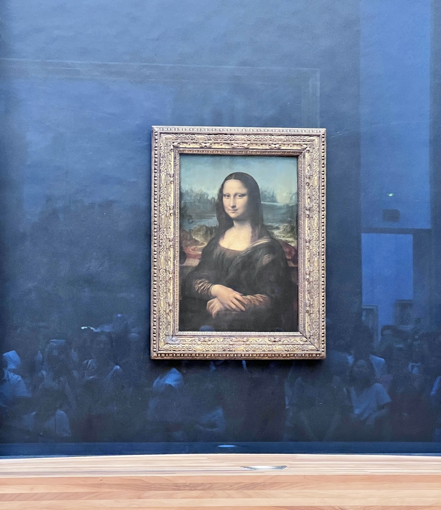 Framed painting of the Mona Lisa on a blue wall with a subtle reflection of a crowd below, conveying a sense of admiration and curiosity.