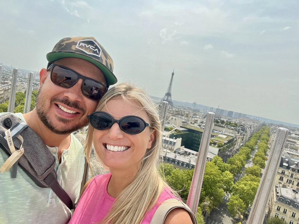 Eiffel Tower and happy travelers enjoying a sunny day in Paris, France.