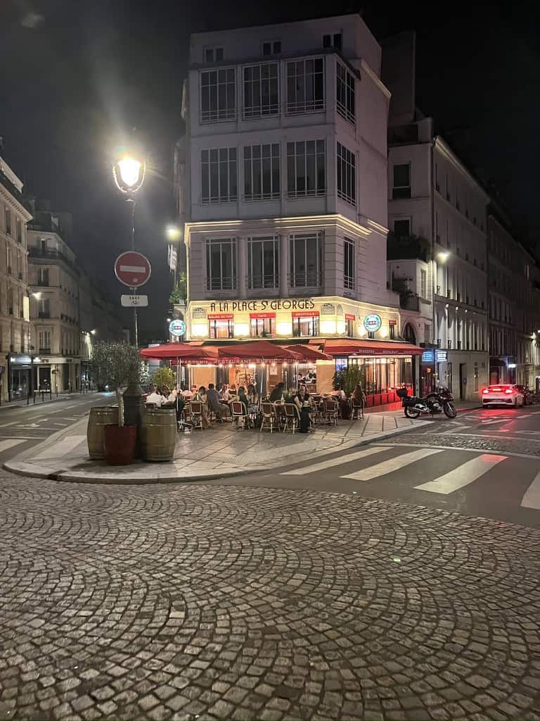 Paris café illuminated with warm lights and outdoor seating.