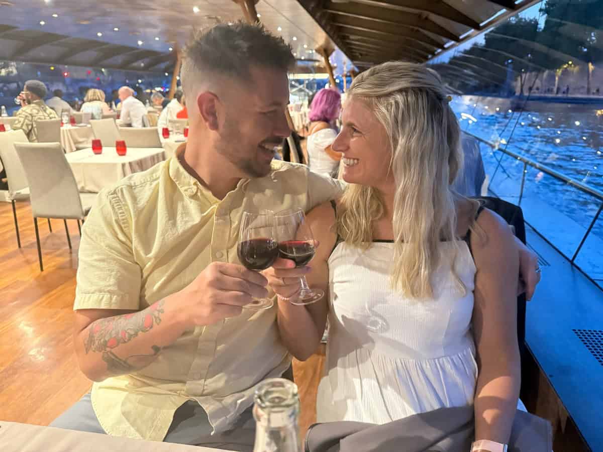 Romantic couple enjoying wine toast on a boat during sunset.