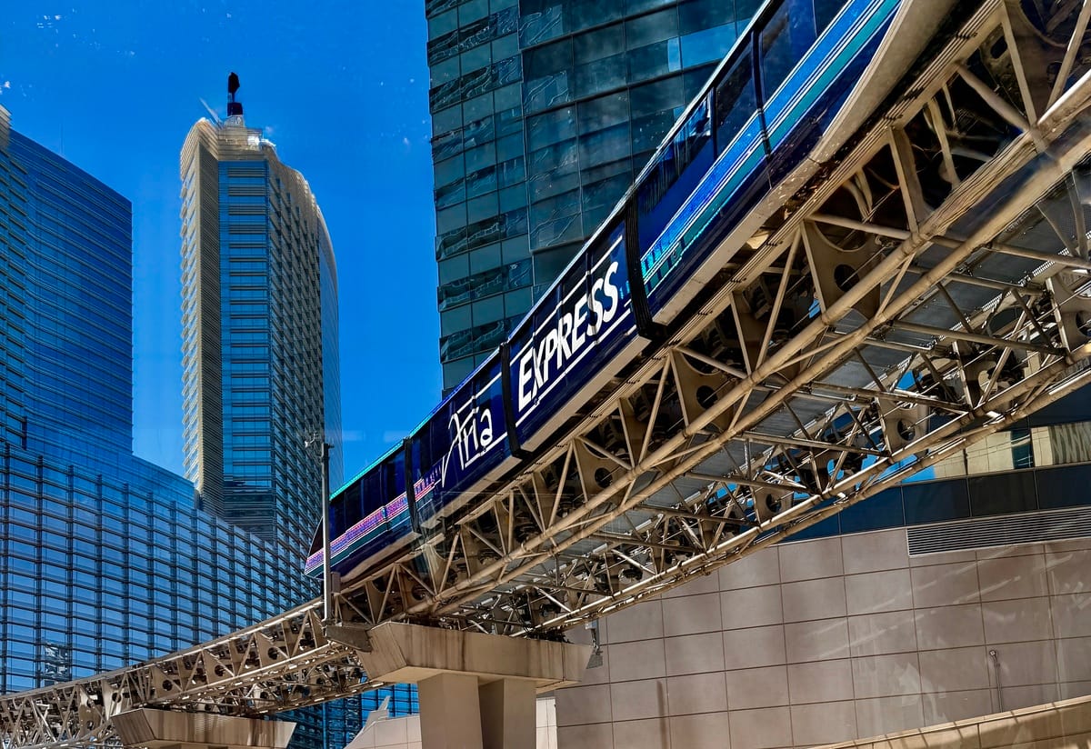 Vibrant cityscape with modern skyscrapers and an elevated train in downtown.