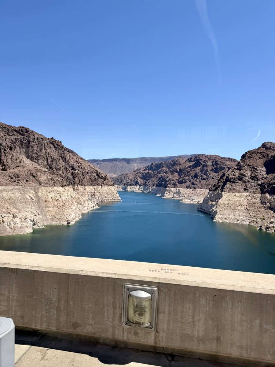 Majestic view of Lake Mead at Hoover Dam with rugged canyon walls under clear blue sky.