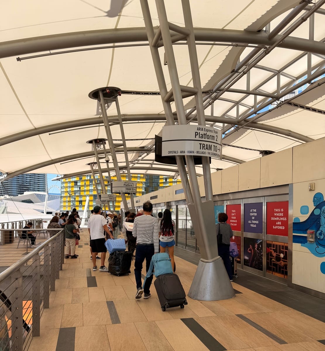 Travelers at airport terminal with luggage, modern architecture, and signage.