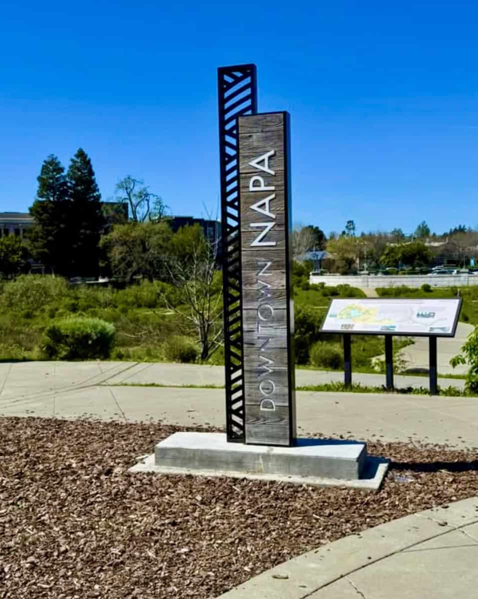 Downtown Napa sign with clear blue sky and greenery in the background.