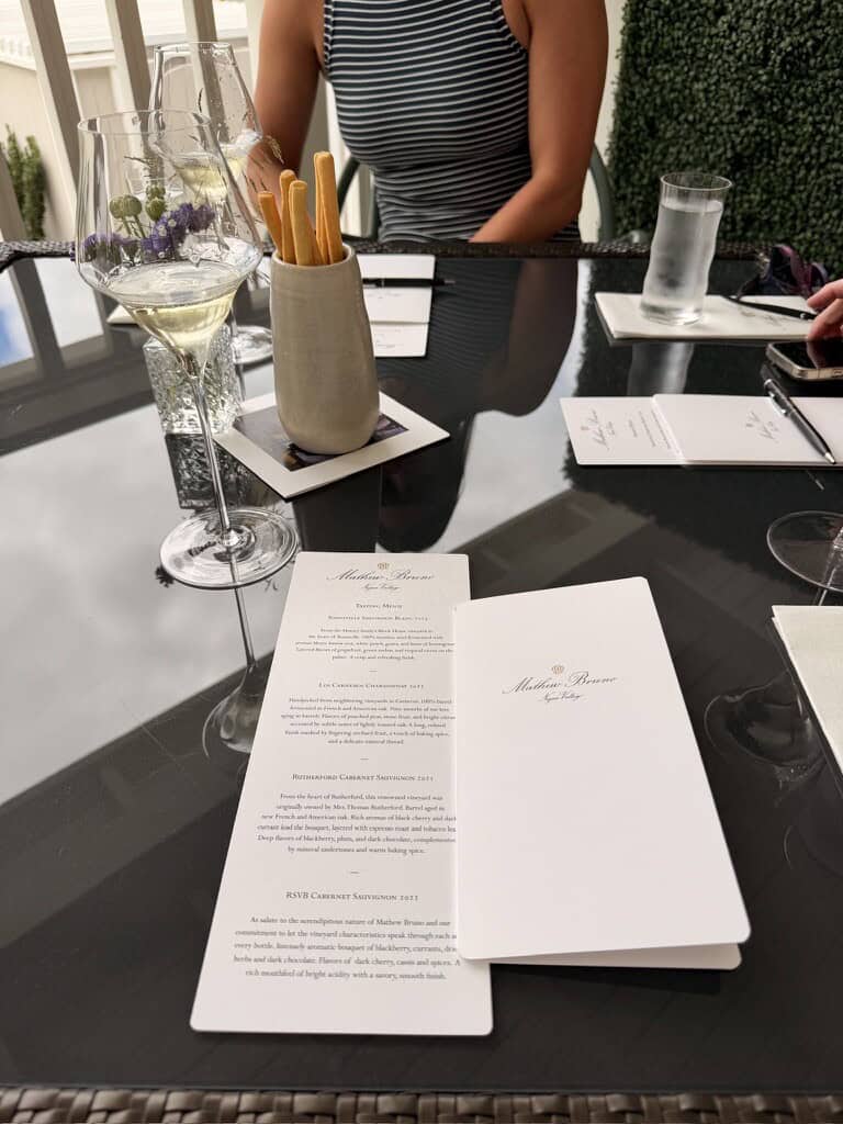 Elegant dining table setup with wine glass, menu, and water glass at a restaurant.