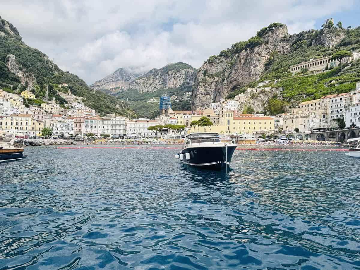 Scenic view of Amalfi Coast with colorful buildings and boat in the water.