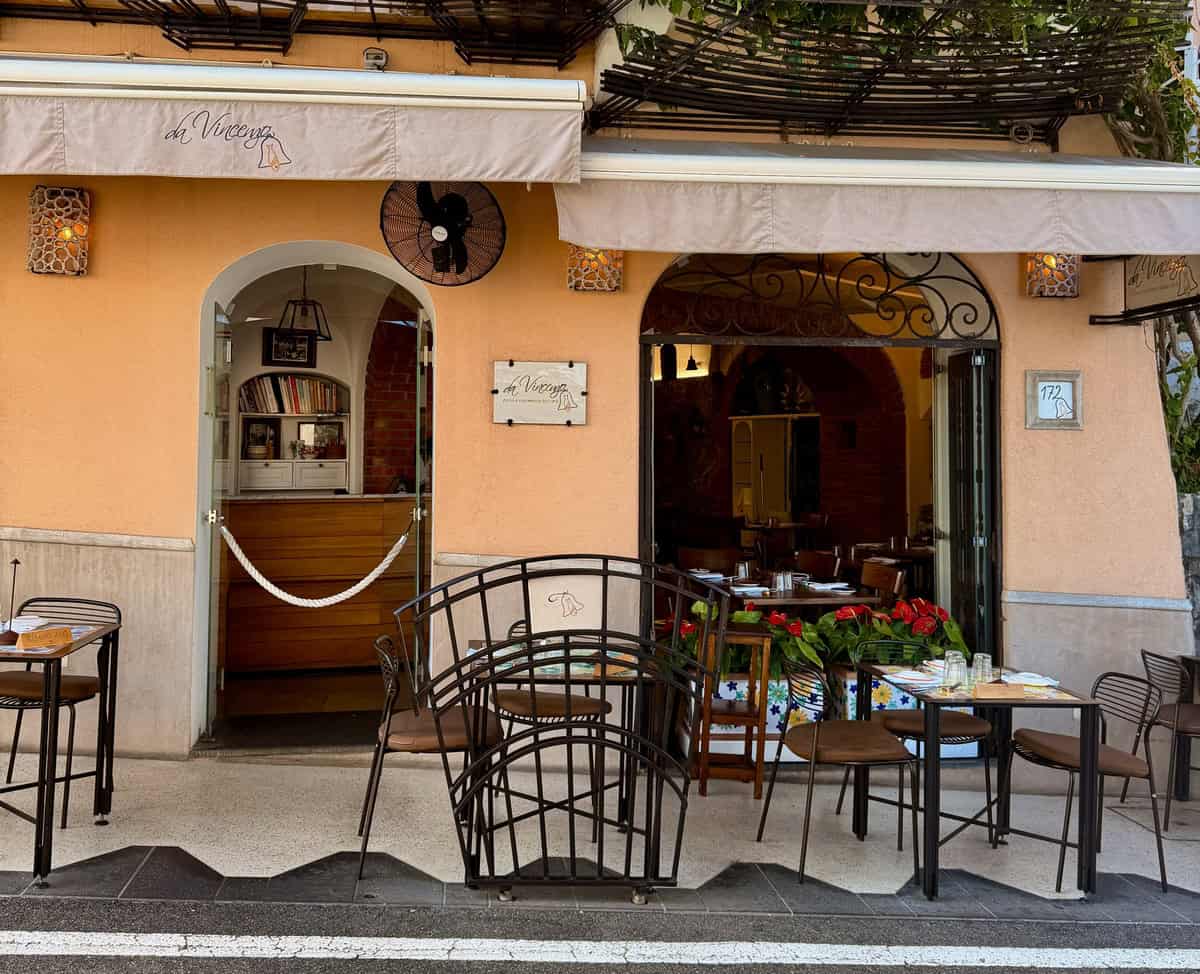 Charming outdoor cafe with tables and chairs in a colorful street setting.