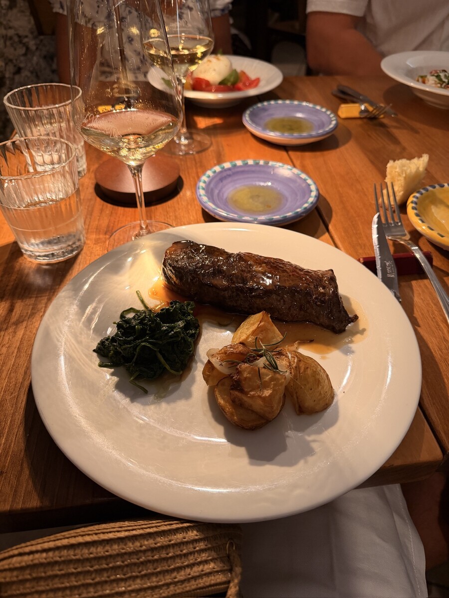Delicious roasted beef with vegetables and greens on a dinner plate.