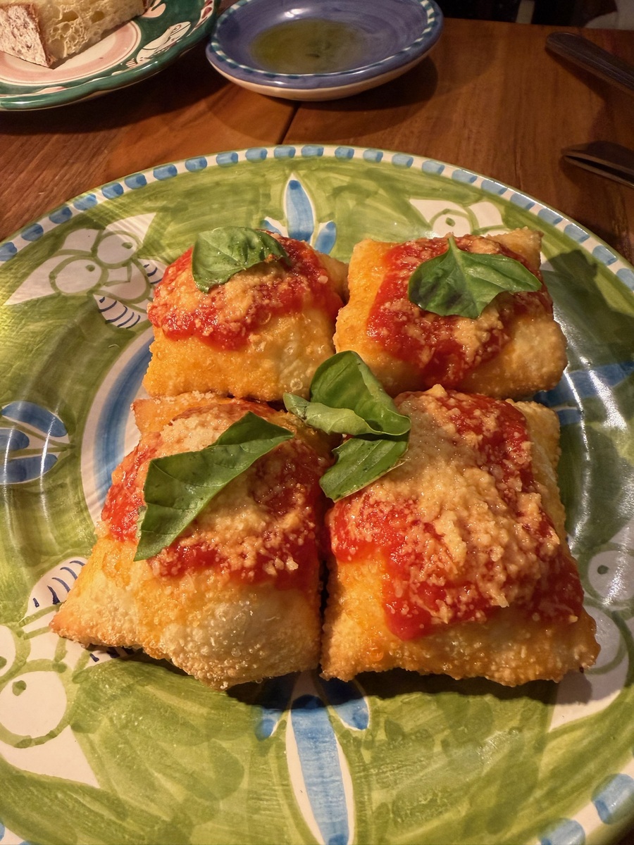 Delicious Italian fried mozzarella sticks with basil on a decorative plate.