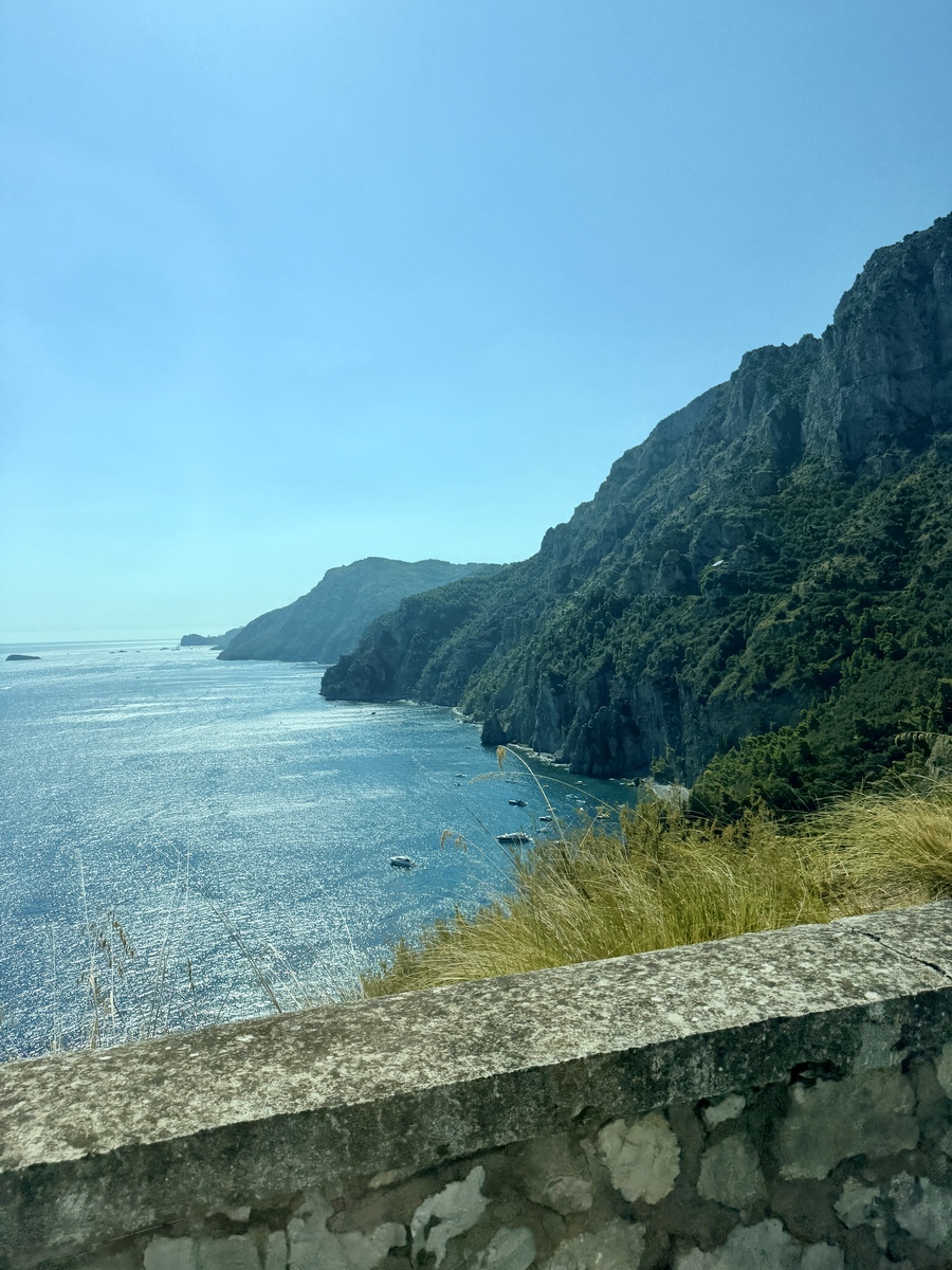 Scenic view of the Amalfi Coast with cliffs and blue sea under clear sky.