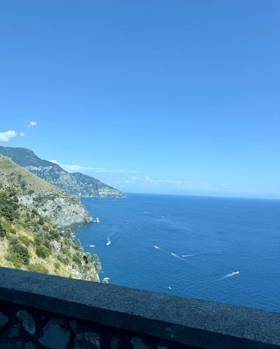 Scenic view of the Amalfi Coast with blue sea and cliffs under a clear sky.