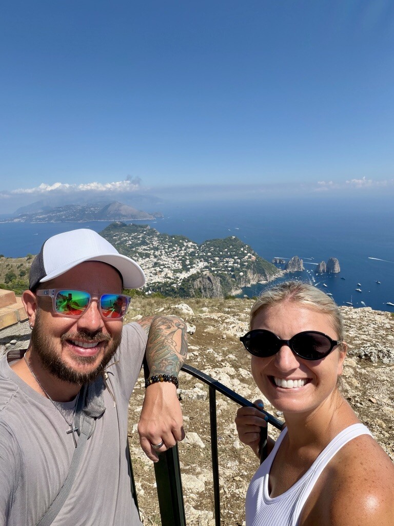 Travelers enjoying panoramic view of Amalfi Coast from high vantage point.