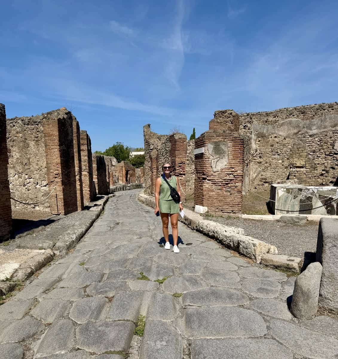 Tourist exploring ancient ruins in Pompeii, Italy on a sunny day.