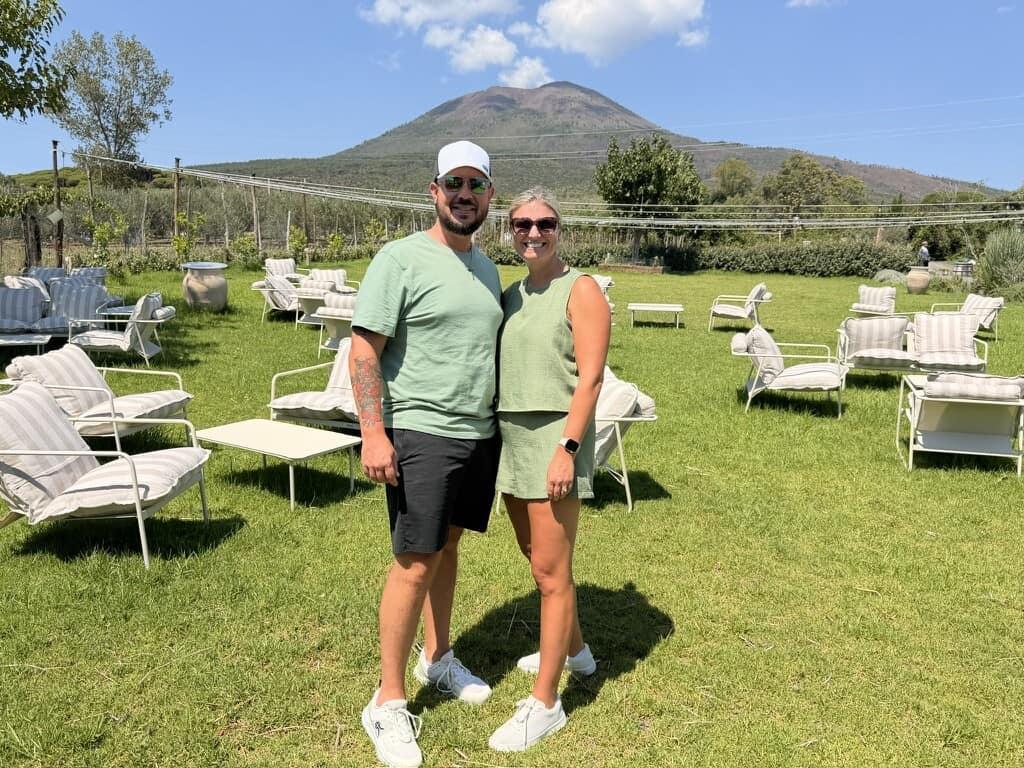 Couple enjoying outdoor scenery with mountain in background during Italy trip.